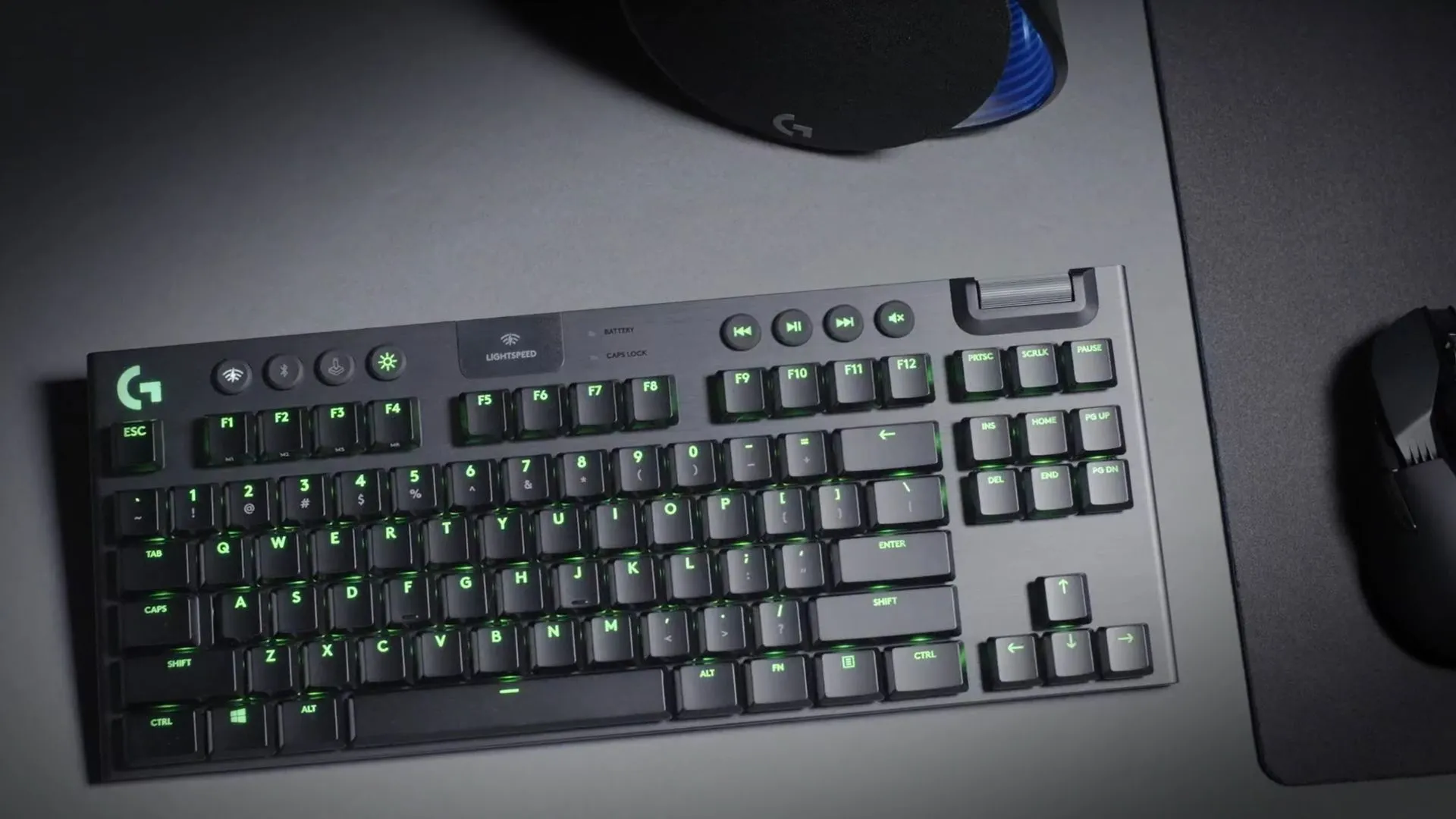 Bàn phím Logitech G915 TKL đặt trên mặt bàn màu xám, thể hiện thiết kế không dây gọn gàng và hiện đại.