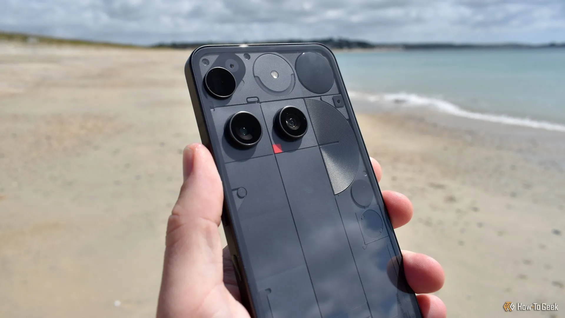 Cận cảnh cụm camera và mặt lưng trong suốt của Nothing Phone (3) trên bãi biển