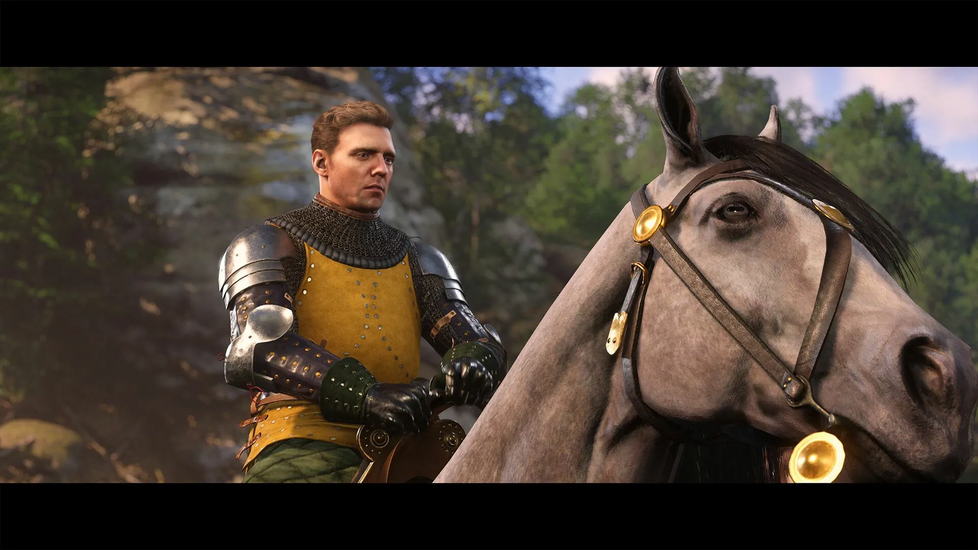 Cận cảnh nhân vật chính Henry trong game Kingdom Come: Deliverance II, thể hiện đồ họa chi tiết và trang phục thời trung cổ.