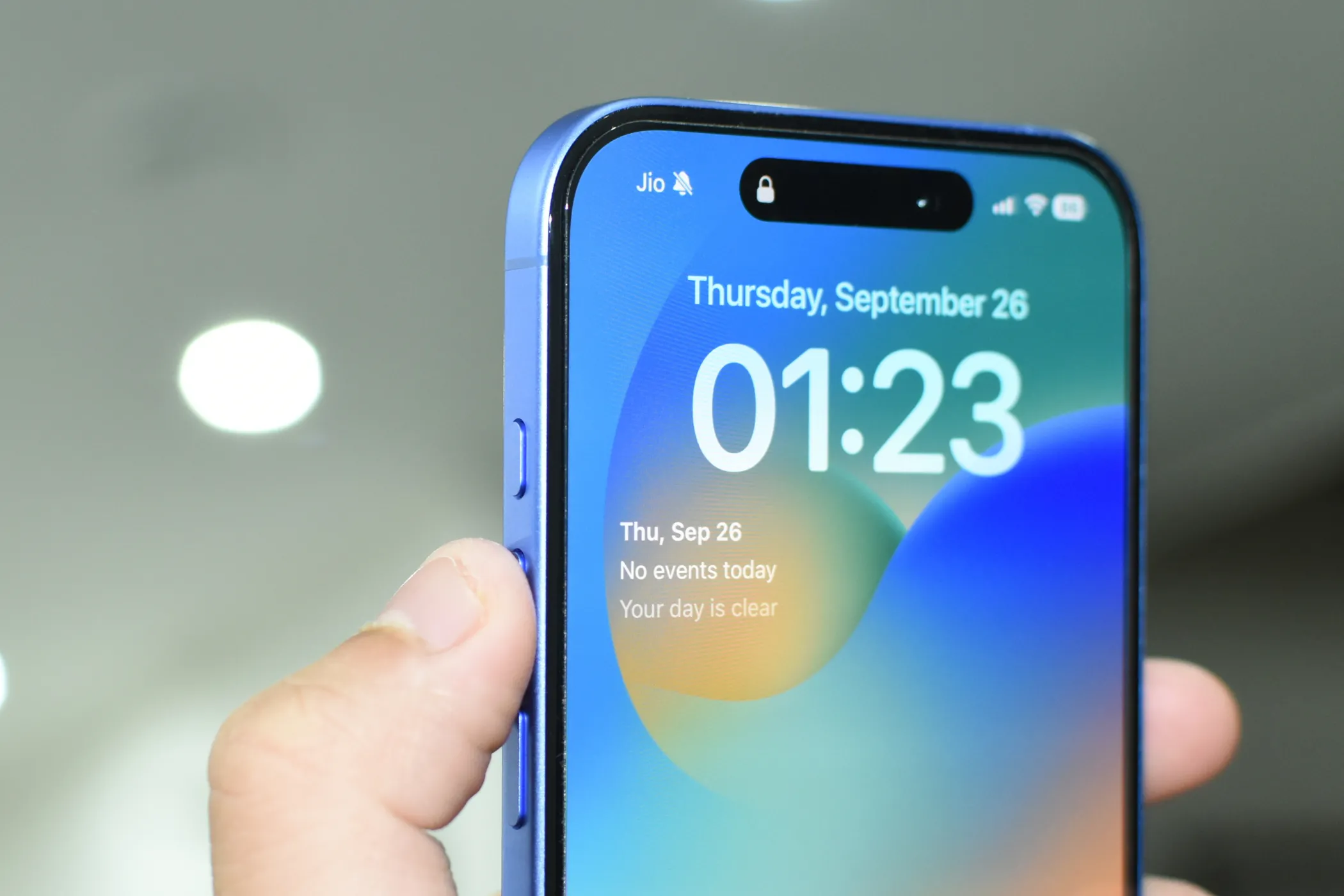 Chiếc iPhone với ngón tay chỉ vào Nút Hành động (Action Button) ở cạnh bên, biểu thị khả năng tùy chỉnh phím tắt.