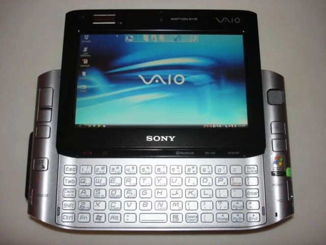 Chiếc laptop Sony VAIO UX Series màu bạc nhỏ gọn được cầm trong lòng bàn tay, với màn hình trượt và bàn phím QWERTY lộ ra