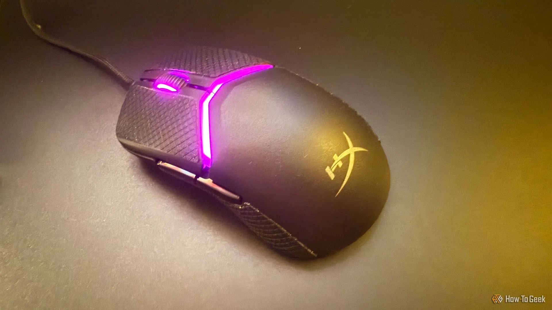 Chuột HyperX Pulsefire Saga trên bàn di chuột kính, thể hiện sự mượt mà khi di chuyển.