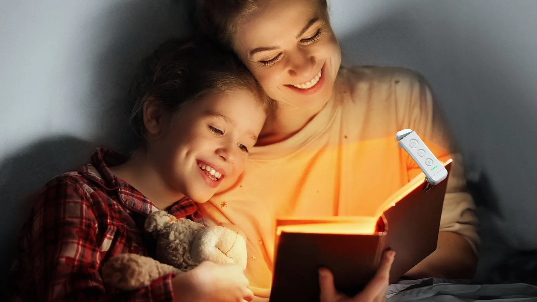 Đèn đọc sách Glocusent Rechargeable Book Light màu đen kẹp trên một cuốn sách vật lý đang mở.