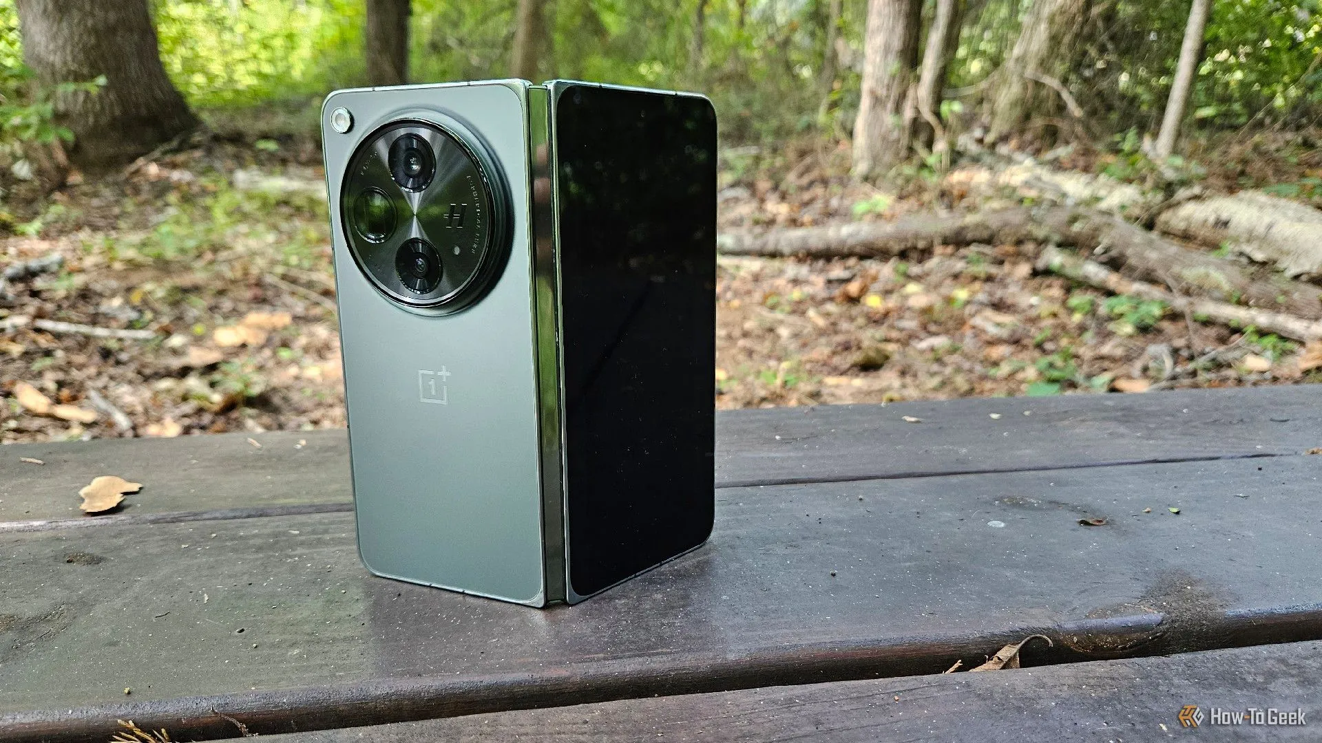 Điện thoại OnePlus Open đang đứng vững trên một băng ghế, thể hiện thiết kế sang trọng và khả năng đứng độc lập của dòng smartphone gập này.