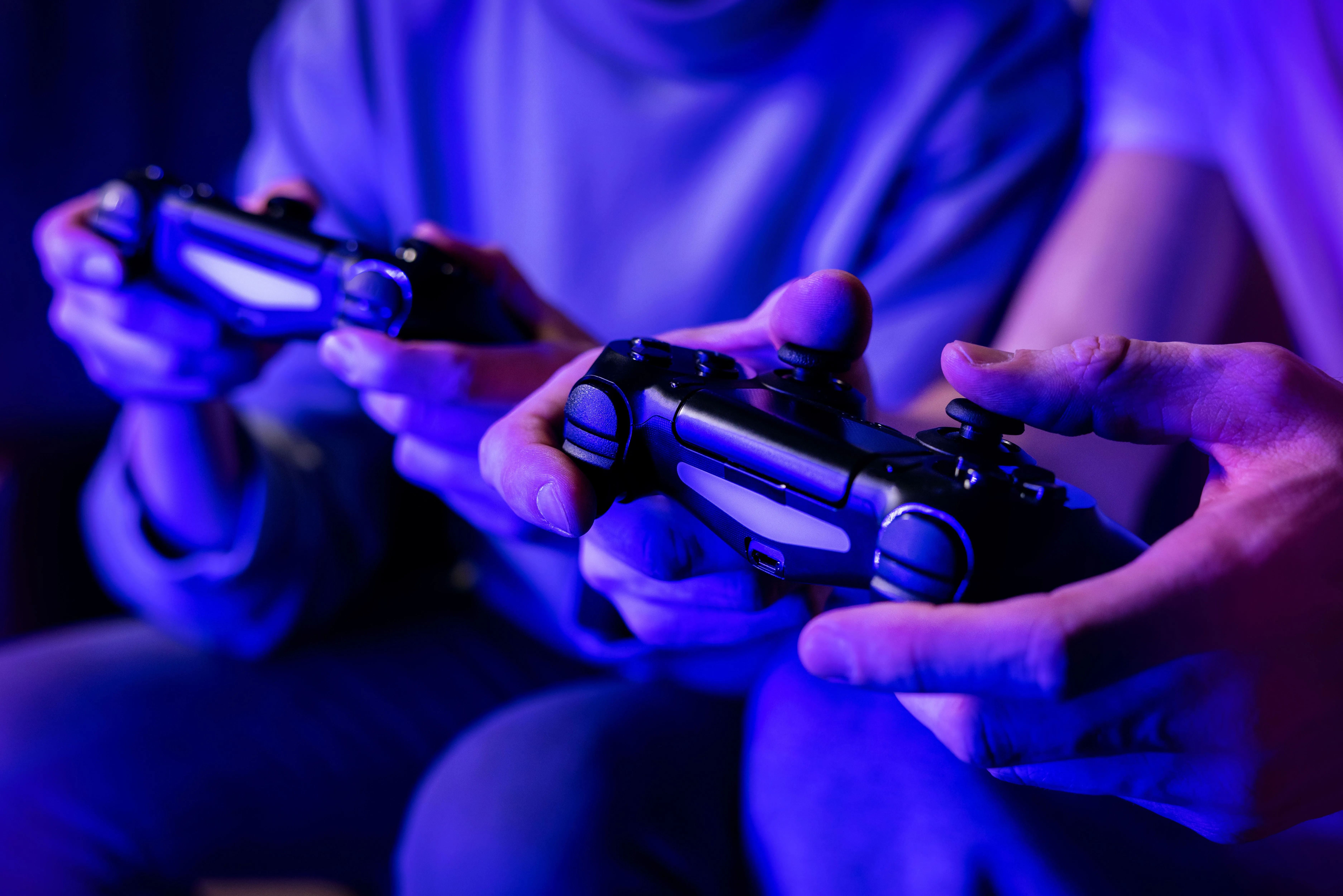Hai người bạn đang chơi game với tay cầm, thể hiện sự tương tác trực tiếp với điều khiển phản hồi để có trải nghiệm chơi game mượt mà.