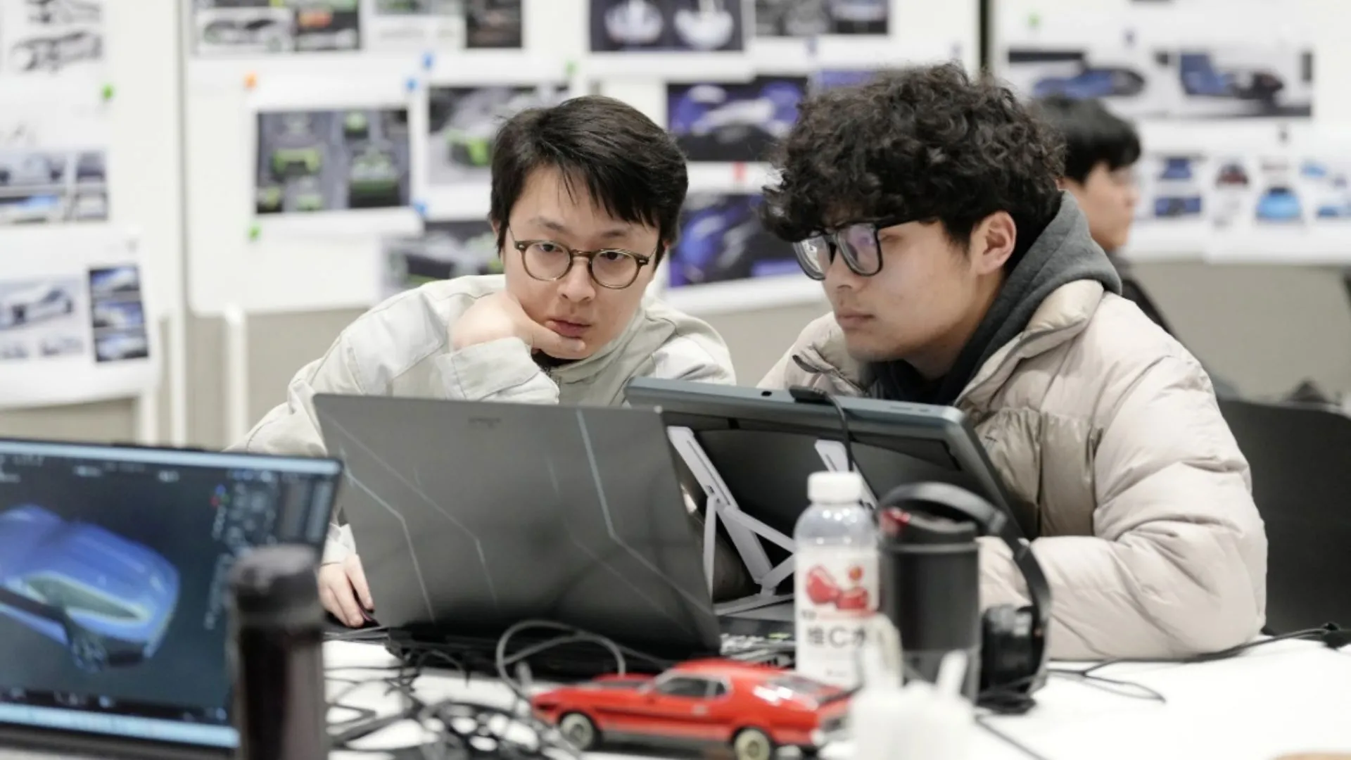 Hai sinh viên đang làm việc trên máy tính xách tay tại trung tâm thiết kế Ford Thượng Hải, minh họa quá trình phát triển ý tưởng Mustang