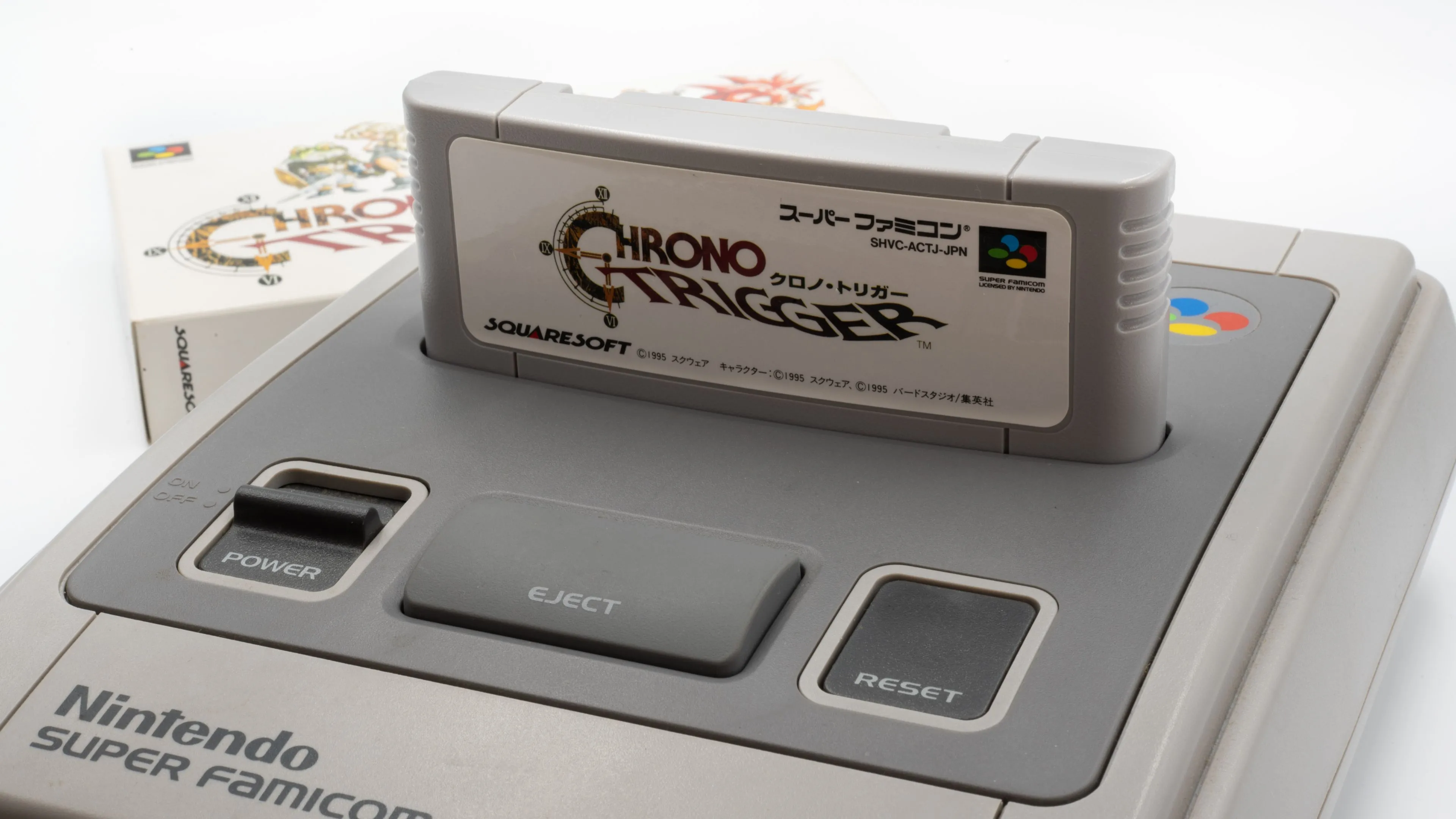 Hộp băng game Chrono Trigger được cắm vào máy chơi game Super Famicom (SNES) cổ điển.