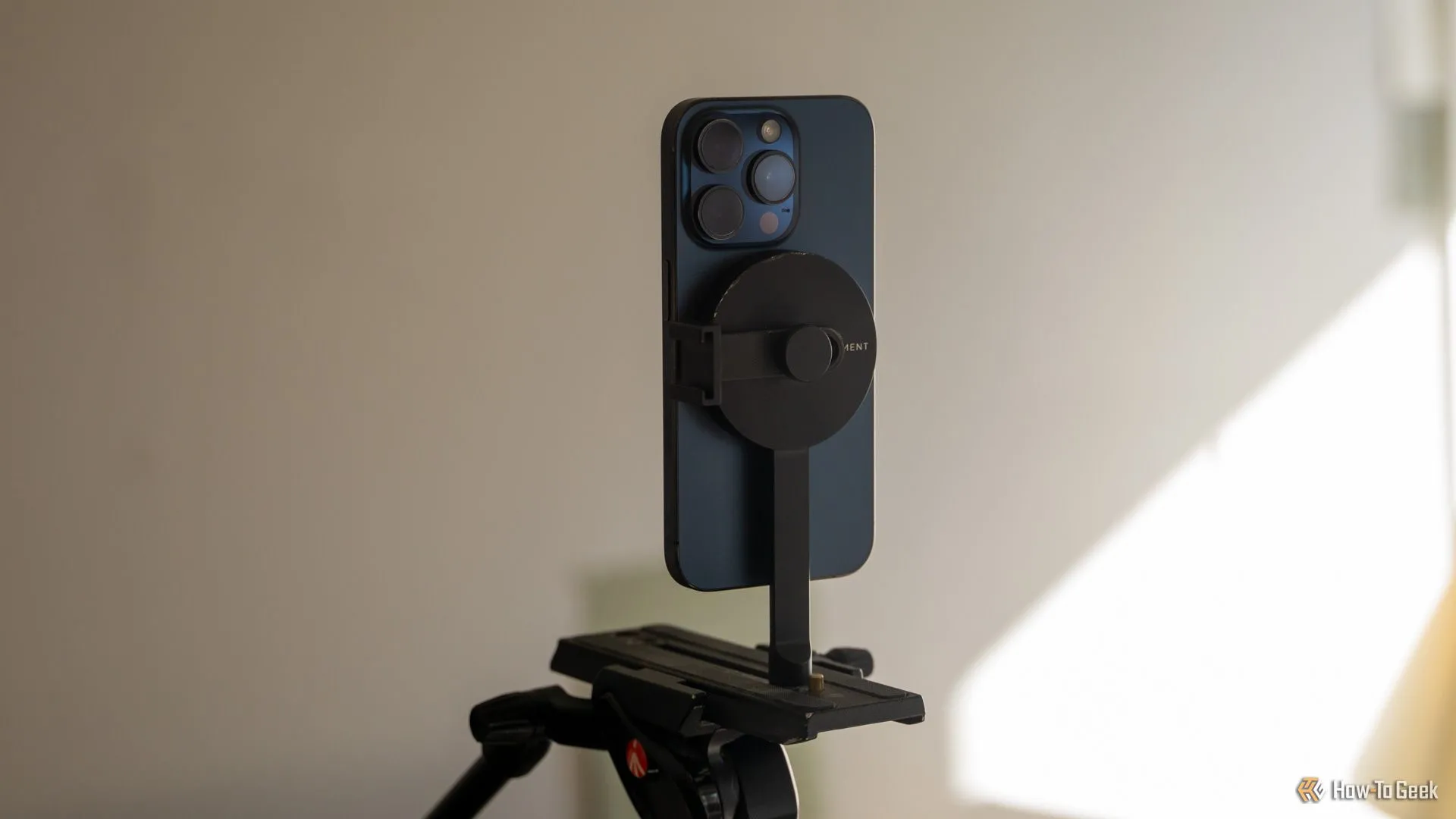 iPhone 15 Pro gắn dọc trên giá đỡ tripod Moment MagSafe, thể hiện khả năng xoay linh hoạt.