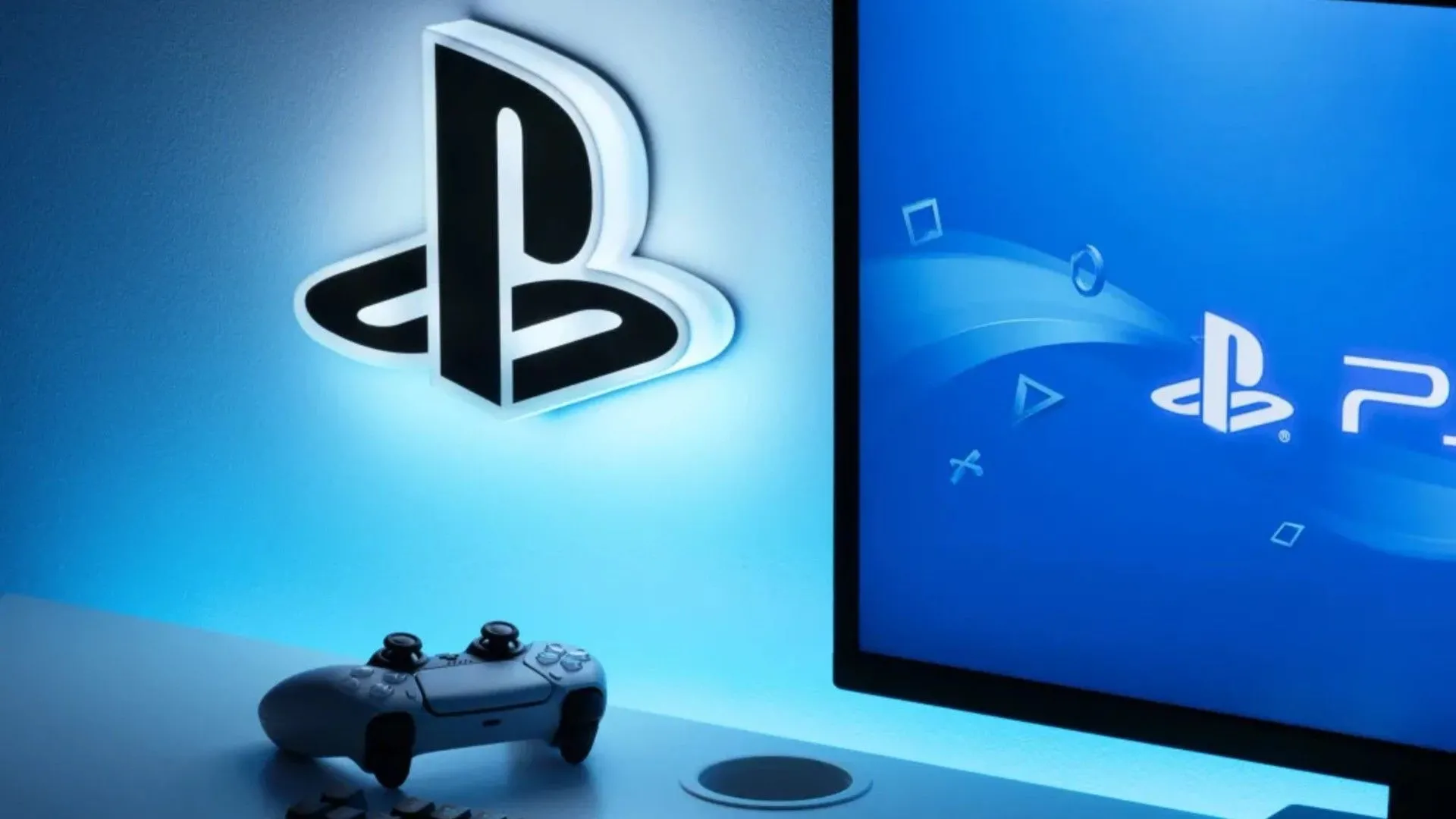 Logo PlayStation phát sáng trên tường, bên cạnh tay cầm DualSense PS5 và màn hình hiển thị biểu tượng PS5, tượng trưng cho sự tăng trưởng doanh số vượt bậc của Indiana Jones and the Great Circle trên nền tảng PlayStation 5.