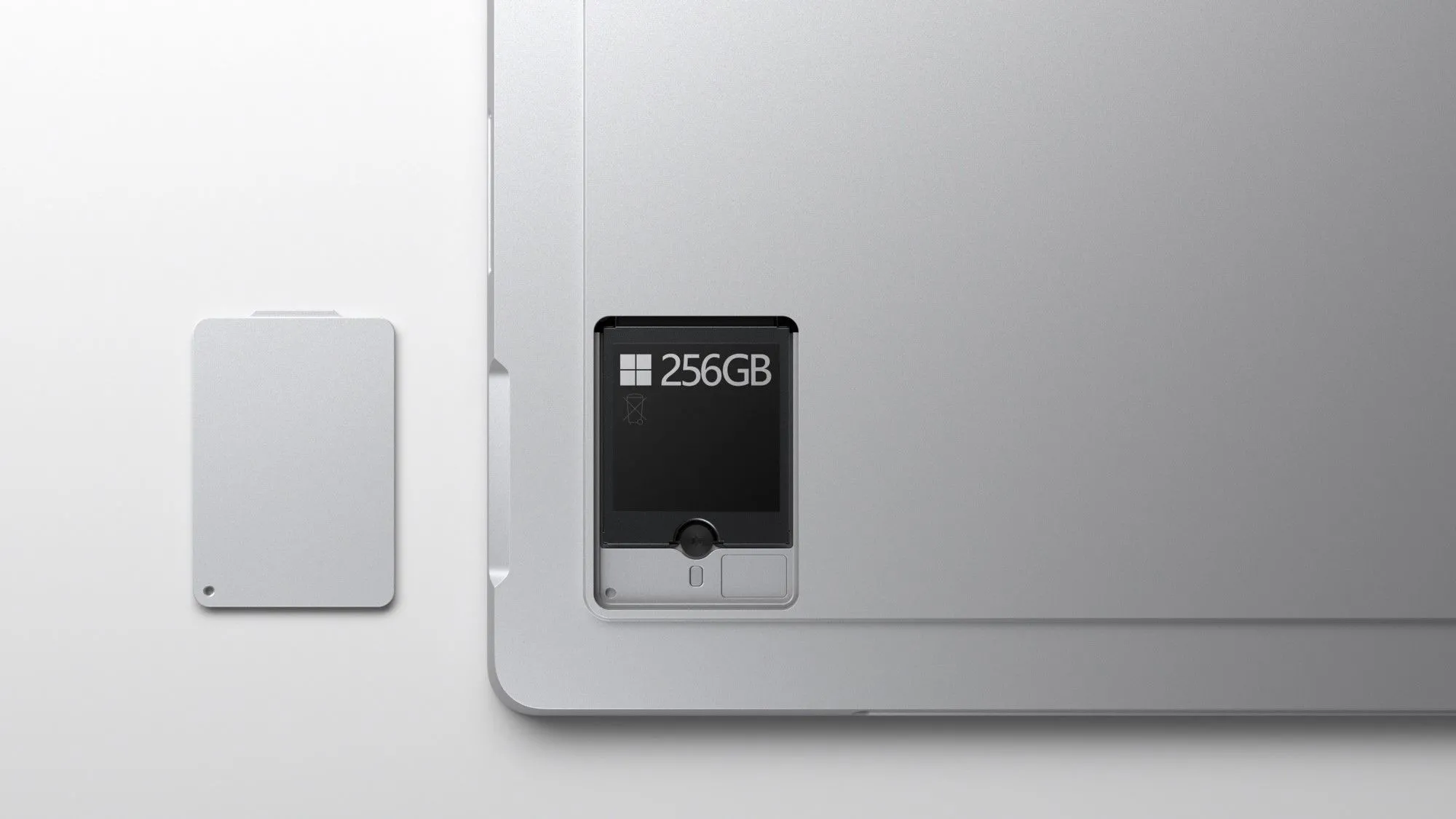 Máy tính Microsoft Surface với nắp đậy ổ SSD được tháo rời, cho thấy cơ chế nâng cấp lưu trữ tiện lợi.