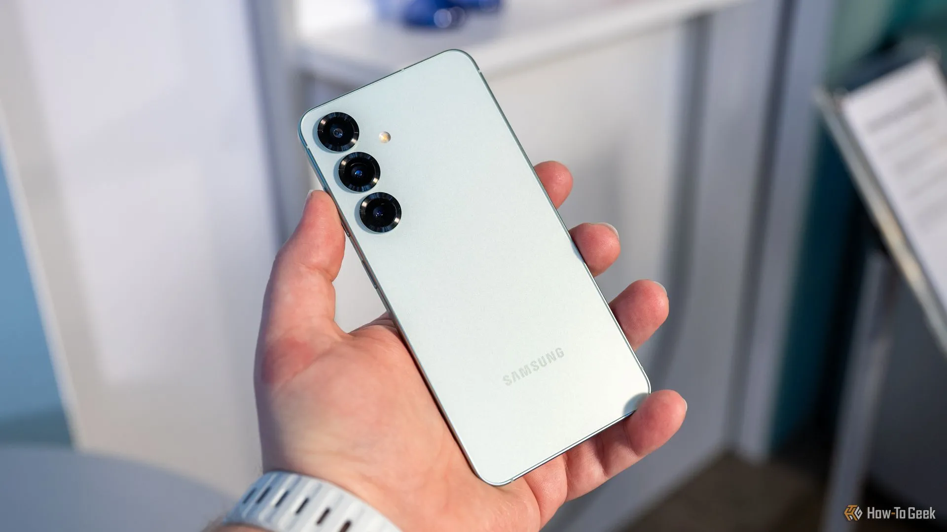 Một người đang cầm điện thoại Samsung Galaxy S25, nhìn vào cụm camera sau.