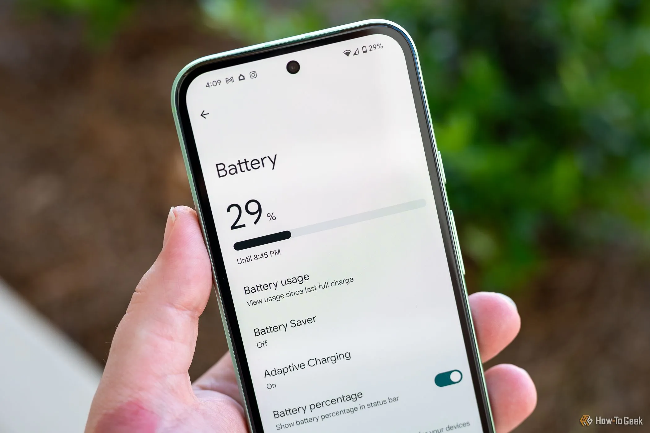 Người dùng cầm Pixel 8a hiển thị menu cài đặt pin, cho thấy thông tin về thời lượng pin và các chế độ tiết kiệm năng lượng.