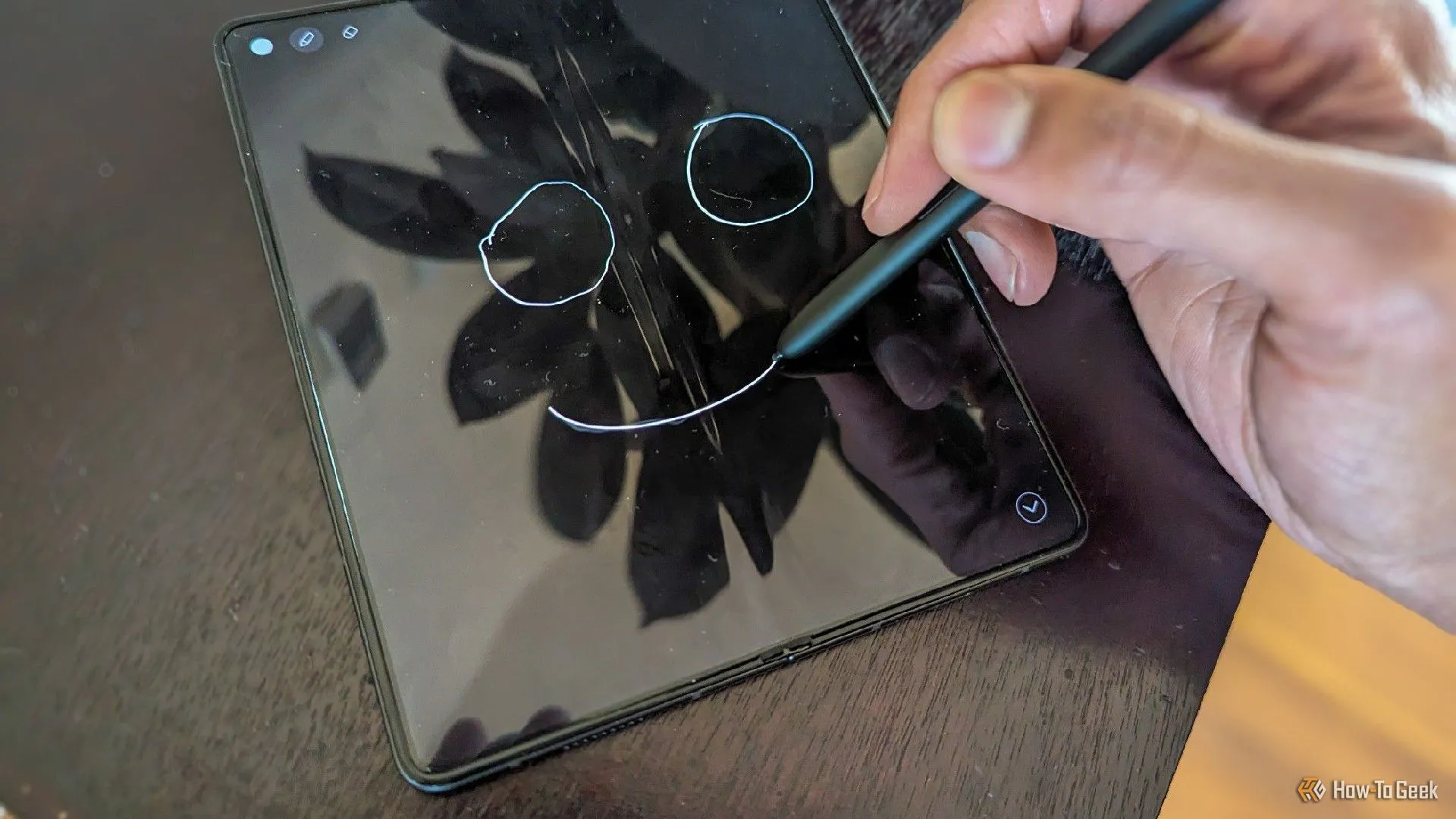 Người dùng đang phác thảo hoặc ghi chú trên Samsung Galaxy Z Fold 5 bằng bút S Pen, thể hiện khả năng sáng tạo của điện thoại gập.