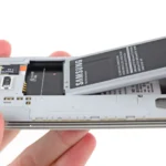 Người dùng đang tháo pin khỏi điện thoại Samsung Galaxy S5.