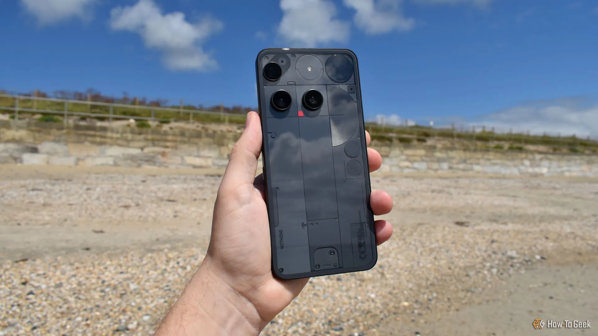 Nothing Phone (3) trên tay người dùng tại bãi biển, thể hiện kích thước và trải nghiệm cầm nắm