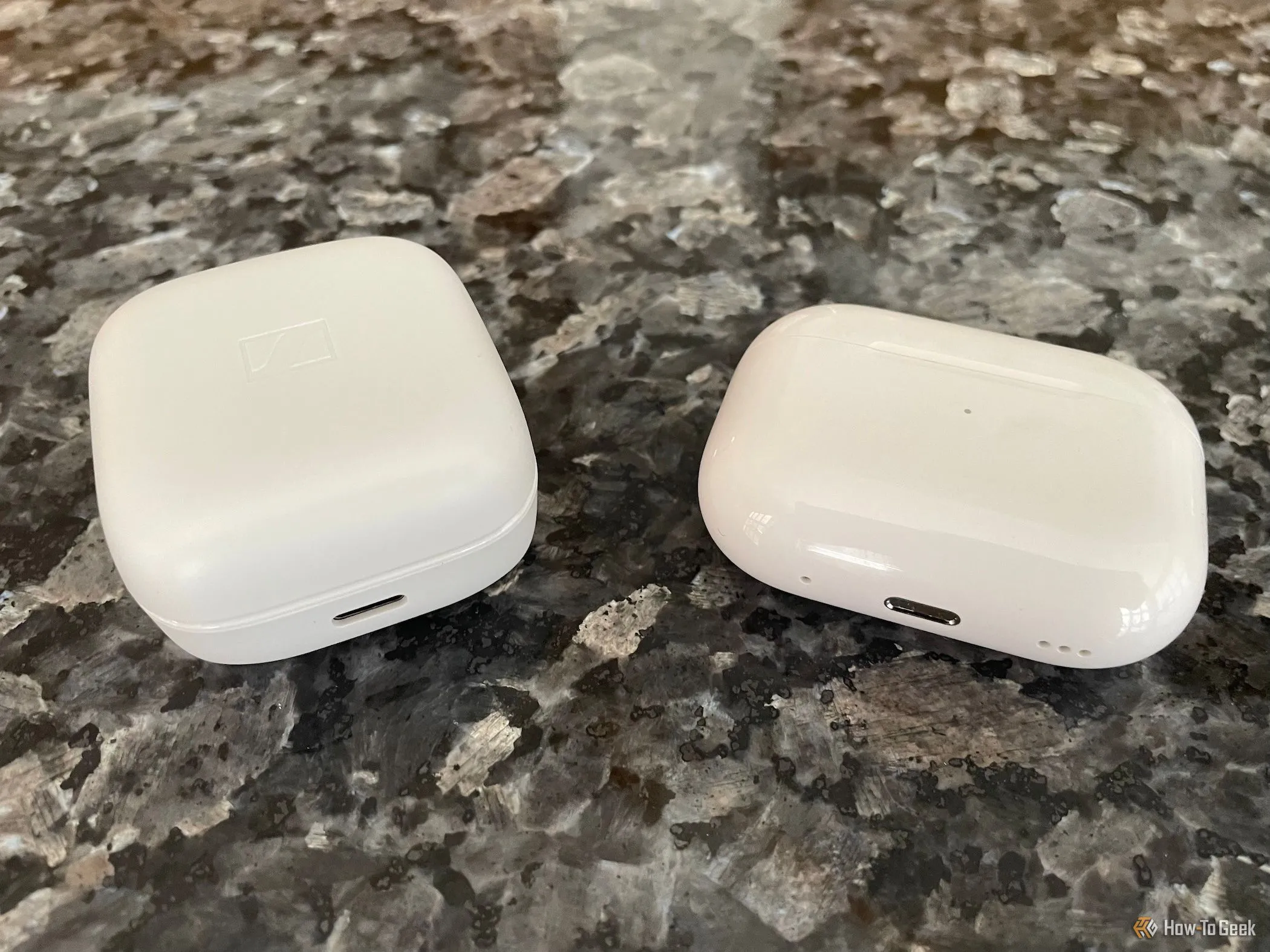 Tai nghe AirPods Pro màu trắng bên cạnh hộp sạc và tai nghe Sennheiser Accentum True Wireless, so sánh thiết kế và kích thước.