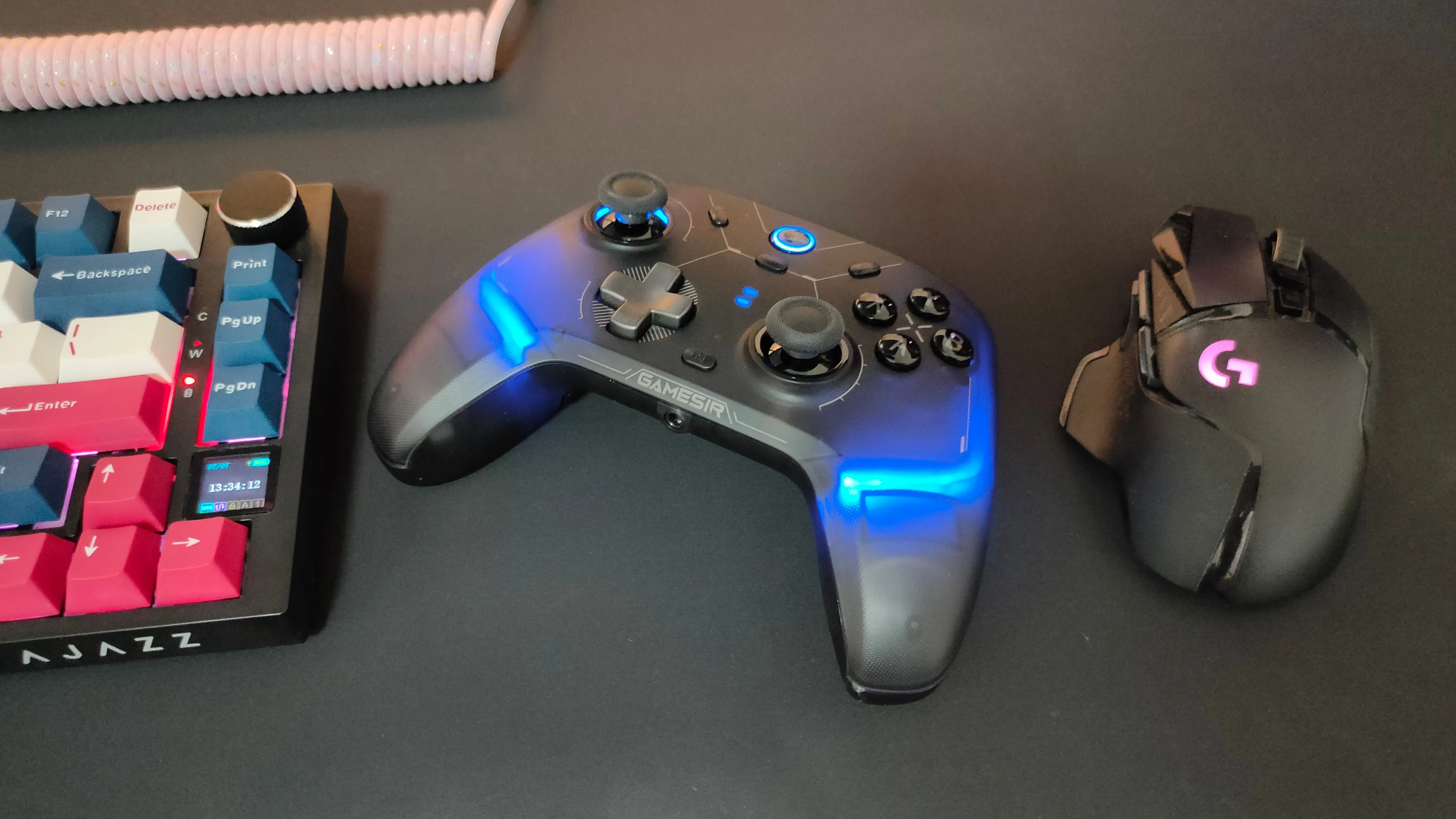 Tay cầm GameSir Cyclone 2 đặt giữa chuột Logitech G502 và bàn phím cơ, thể hiện tính đa dụng cho game thủ.