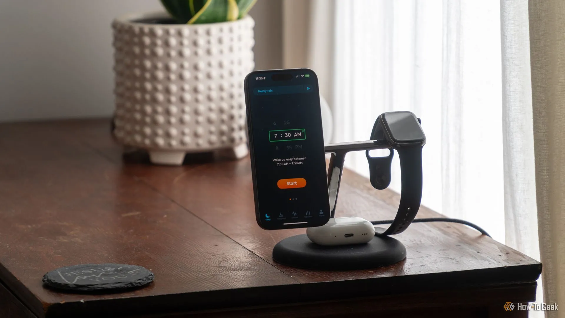 Ứng dụng Sleep Cycle trên iPhone 15 Pro đặt trên bàn cạnh giường ngủ, minh họa cách sử dụng điện thoại để theo dõi giấc ngủ.