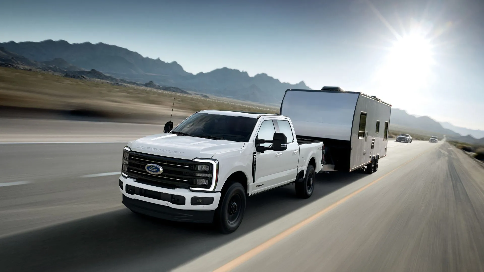Xe bán tải Ford F-350 Super Duty Platinum 2025 màu trắng kéo rơ moóc, phông nền núi non, biểu thị lỗi hệ thống phanh xe Super Duty.