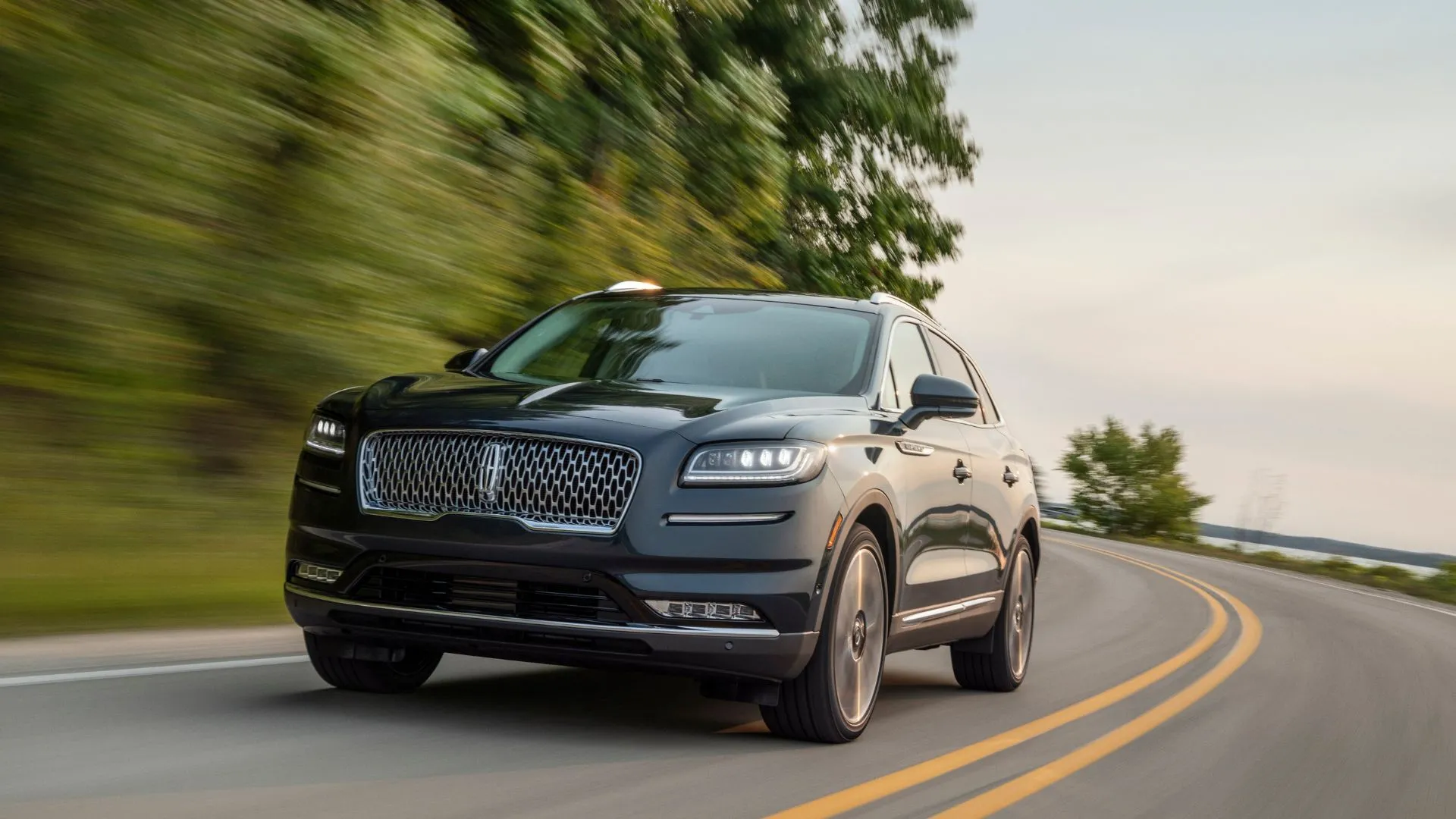 Xe Lincoln Nautilus 2021 màu xanh dương đang di chuyển trên con đường quanh co